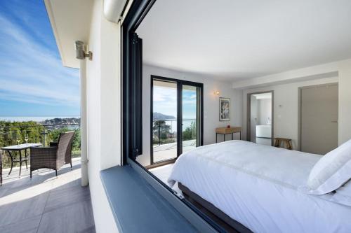 a bedroom with a large bed and a balcony at Sunnydaze, 4 bed V/F pool villa in Villefranche-sur-Mer