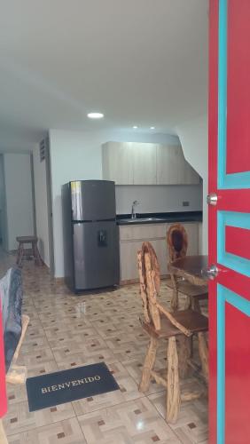 a kitchen with a refrigerator and a table and chairs at APARTAMENTO TURISTICO SALENTO QUINDIO R. in Salento