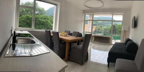cocina y sala de estar con mesa y sillas en Alps Apartments Viktory, en Bolzano