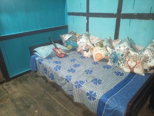 uma cama com almofadas num quarto em Ninabung homestay em Namchi