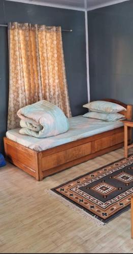 um quarto com uma cama com uma cortina e um tapete em Ninabung homestay em Namchi