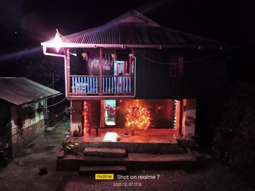 uma casa com um deque e uma lareira no quintal em Ninabung homestay em Namchi