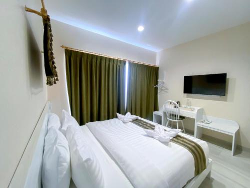 1 dormitorio con cama, escritorio y ventana en Flamingo Ceria, en Labuan Bajo