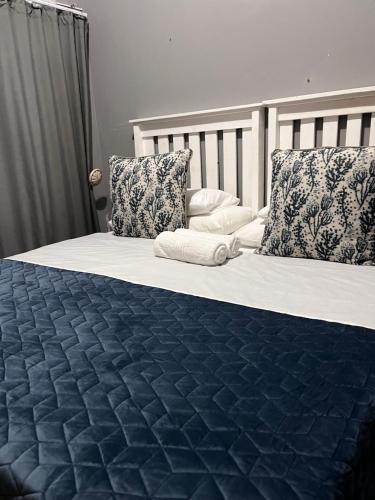 a bedroom with two beds with blue sheets and pillows at Lavender Lodge Twin in Mthatha