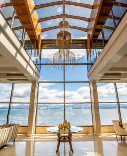 a large room with a table and a chandelier at Alma Del Lago Suites & Spa in San Carlos de Bariloche