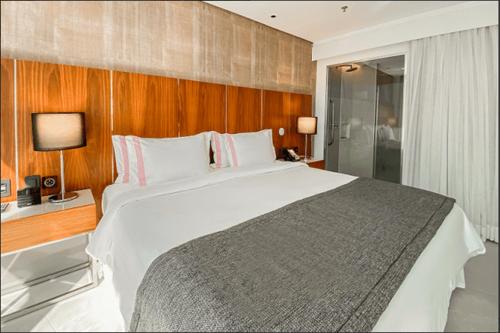 um quarto com uma grande cama branca num quarto em HOTEL NACIONAL BLOCO 01 1512/013 no Rio de Janeiro