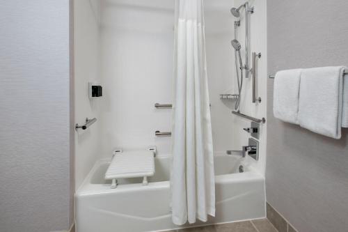 a white bathroom with a tub and a shower at Courtyard by Marriott Annapolis in Annapolis