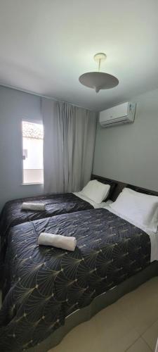 a bedroom with a large bed with two pillows at Casa 109 COND BRISAS DO FAROL n 07 in Salvador