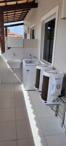 a bathroom with two washing machines and a sink at Casa 109 COND BRISAS DO FAROL n 07 in Salvador