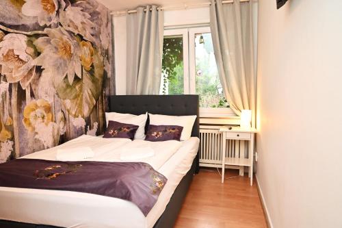 ein Schlafzimmer mit einem Bett mit einer Blumenwand in der Unterkunft Self check in City Hostel Nordstern in Essen