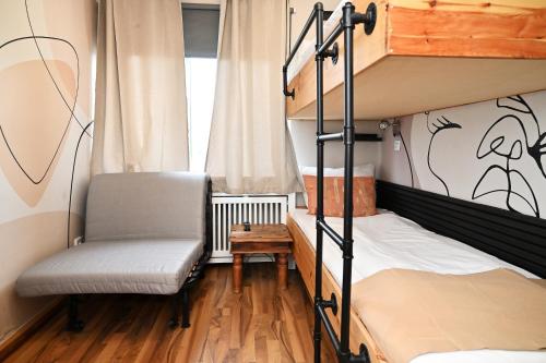 a bedroom with two bunk beds and a chair at Self check in City HoStel Nordstern in Essen