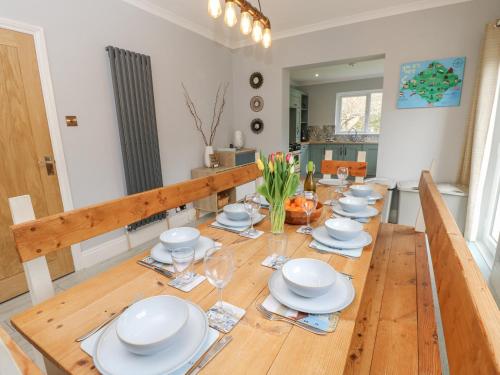 a dining room with a wooden table with white dishes at Morningside in Totland