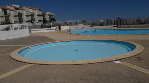 une grande piscine bleue dans un parking dans l'établissement les goelettes, à Saint-Cyprien