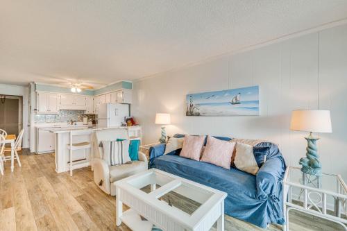a living room with a blue couch and a kitchen at Chic Condo with Ocean Views and Pool - Walk to Beach! in Atlantic Beach