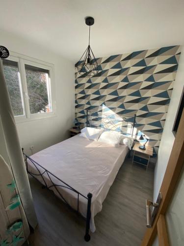 une chambre avec un lit avec un mur bleu et blanc dans l'établissement vue panoramique, à Amélie-les-Bains-Palalda