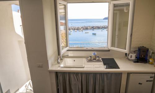 baño con lavabo y ventana en La terrazza di Maria en Procida