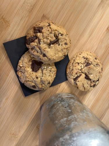 three chocolate chip cookies on a table with a bottle of water at Agriturismo Il Gonzeto, Montepulciano in Montepulciano