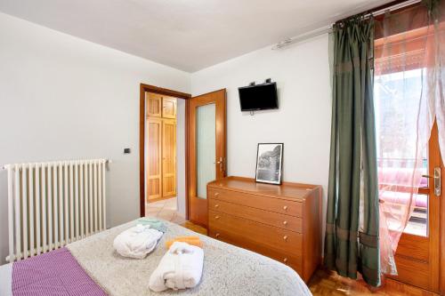 Un dormitorio con una cama y un tocador con toallas. en La Maison des Jumeaux, en Châtillon