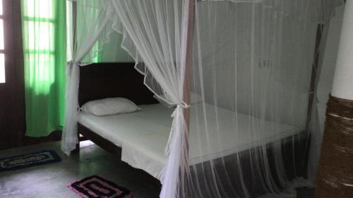 a bed with a canopy in a room at HAPPY REST in Unawatuna