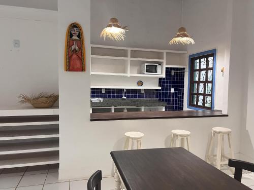 eine Küche mit einem Tisch und Stühlen in der Unterkunft Zil Hospeda in Pipa
