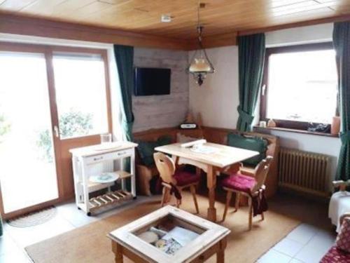 ein Wohnzimmer mit einem Tisch und einem Sofa in der Unterkunft FeWo LEO im AKTIV Landhaus in Missen-Wilhams