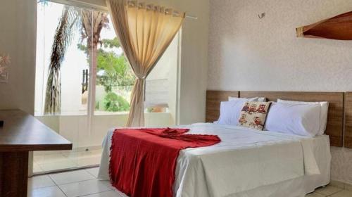 um quarto com uma cama com um cobertor vermelho em HOTEL DA MARGEM em Manaus