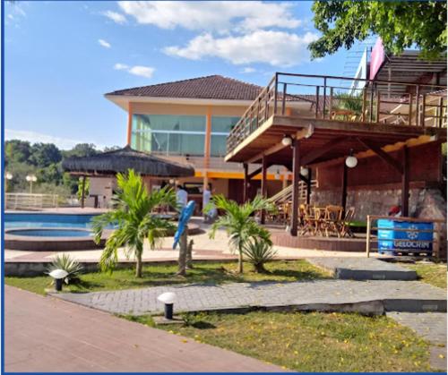 a house with a balcony and a swimming pool at HOTEL DA MARGEM in Manaus