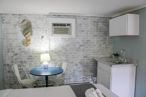 eine kleine Küche mit einem blauen Tisch und Stühlen in der Unterkunft The Janmere Motel in Hampton