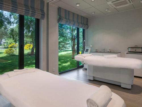 two beds in a room with large windows at Rosevia Resort & Spa in Jastrzębia Góra