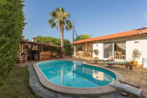 a swimming pool in a yard next to a house at Mini Paradise Salamina - Private Pool Retreat in Salamina