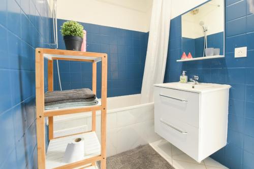 une salle de bain bleue avec un lavabo et un miroir dans l'établissement Appartement hypercentre - Nancy, à Nancy