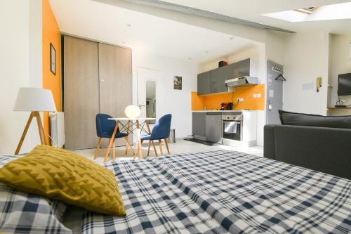 Cet appartement comprend une chambre avec un lit et une cuisine avec des armoires orange. dans l'établissement Appartement hypercentre - Nancy, à Nancy