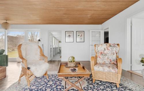 a living room with a chair and a coffee table at Cozy Home In Sydals With Sauna in Sarup