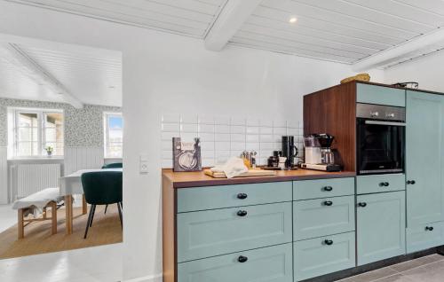 a kitchen with a blue cabinet and a table at Cozy Home In Sydals With Sauna in Sarup