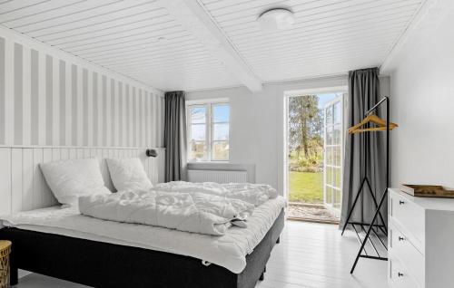 a white bedroom with a large bed and a window at Cozy Home In Sydals With Sauna in Sarup