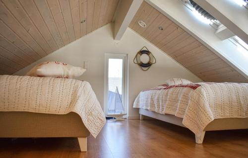 sypialnia na poddaszu z 2 łóżkami i oknem w obiekcie Nice Home In Slvesborg With House Sea View w mieście Sölvesborg