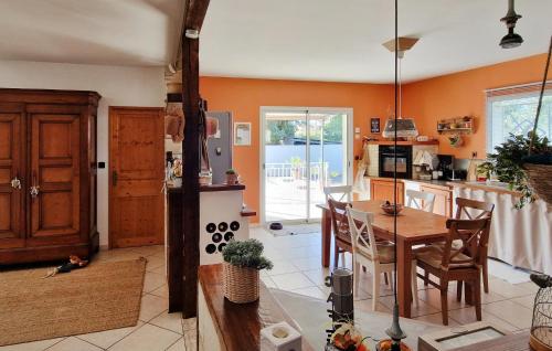 - une cuisine aux murs orange avec une table et des chaises dans l'établissement Gorgeous Home In Vias, à Vias