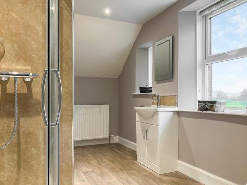 La salle de bains est pourvue d'une douche, d'un lavabo et d'une fenêtre. dans l'établissement Halleaths Home Farm, à Lochmaben