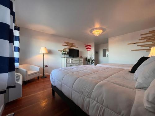 um quarto com uma grande cama branca e um sofá em Acadia Ocean View Hotel em Bar Harbor
