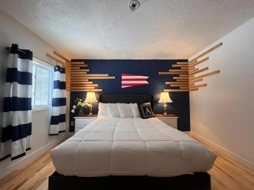 a bedroom with a large white bed with a blue wall at Acadia Ocean View Hotel in Bar Harbor