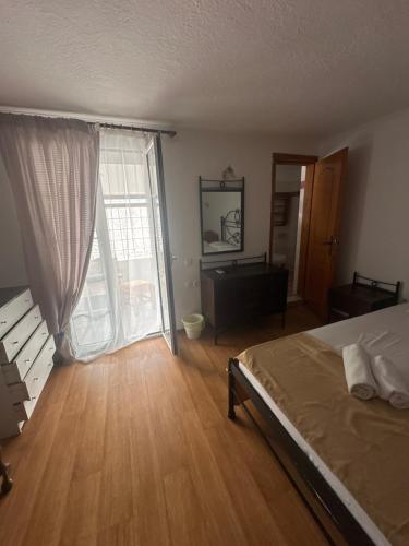 a bedroom with a bed and a large window at Pansion Angela in Skiathos Town