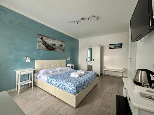 a bedroom with a bed and a blue wall at Fezzano / Portovenere Stilish double rooms with sea view, balcony or small courtyard in Fezzano