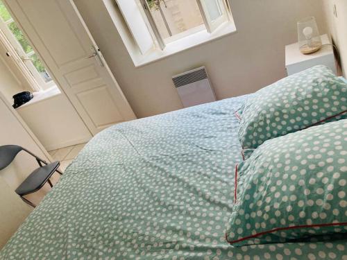 - un lit avec des draps et des oreillers verts dans une chambre dans l'établissement Bel appart t2 lumineux avec terrasse hyper centre., à La Rochelle