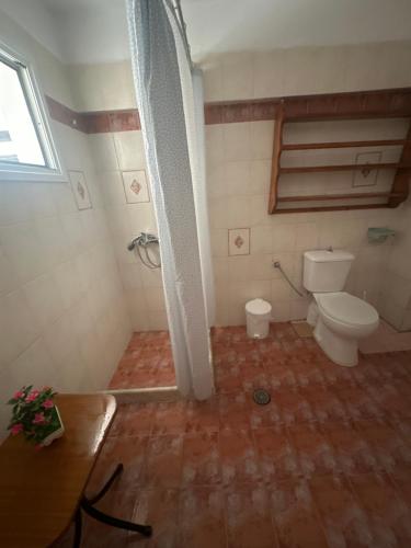 a small bathroom with a toilet and a window at Pansion Angela in Skiathos Town
