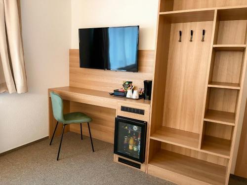a room with a desk with a tv and a chair at Harmony - Schlafen im Stadtzentrum in Meiningen