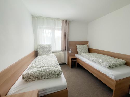 a room with two beds and a window at Harmony - Schlafen im Stadtzentrum in Meiningen