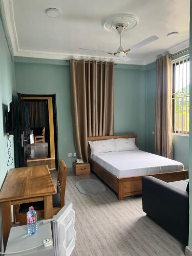 1 dormitorio con cama, mesa y sofá en Jackie Grand Hotel, en Cape Coast