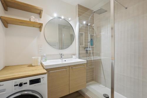 une salle de bain avec un lavabo et une machine à laver dans l'établissement Appartement elegant- Parc Saint Cloud, à Sèvres