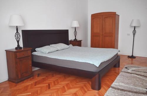 1 dormitorio con 1 cama, vestidor y 2 lámparas en Vintage Dream Apartment, en Oradea