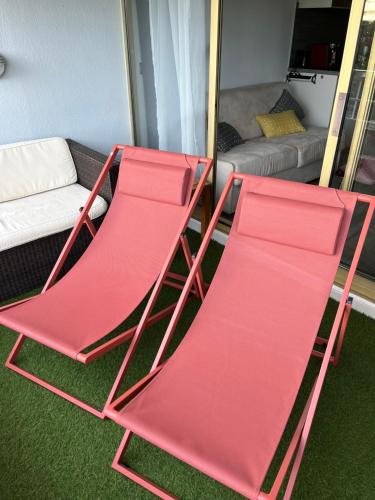 Duas cadeiras dobráveis vermelhas numa sala de estar com um sofá em 4 pers , 100m de la plage marina baie des anges French Riviera em Villeneuve-Loubet